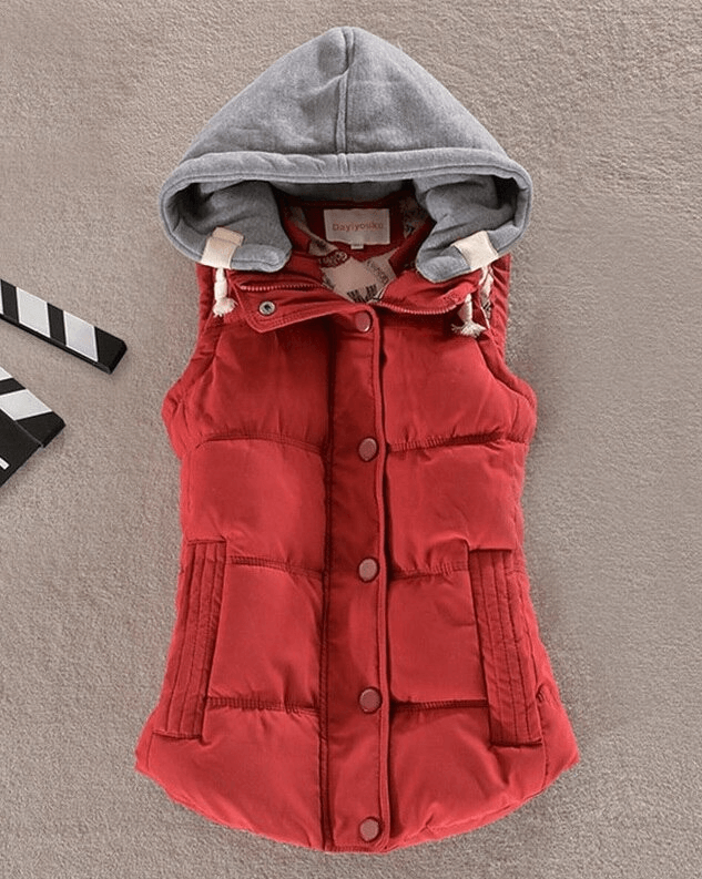 Women's red sleeveless cotton jacket with hood, featuring buttons and pockets, stylishly laid out on a light background.