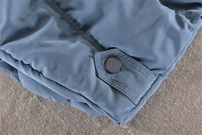 Close-up of women's sleeveless cotton jacket detail showing buttoned pocket on elegant casual hooded vest.