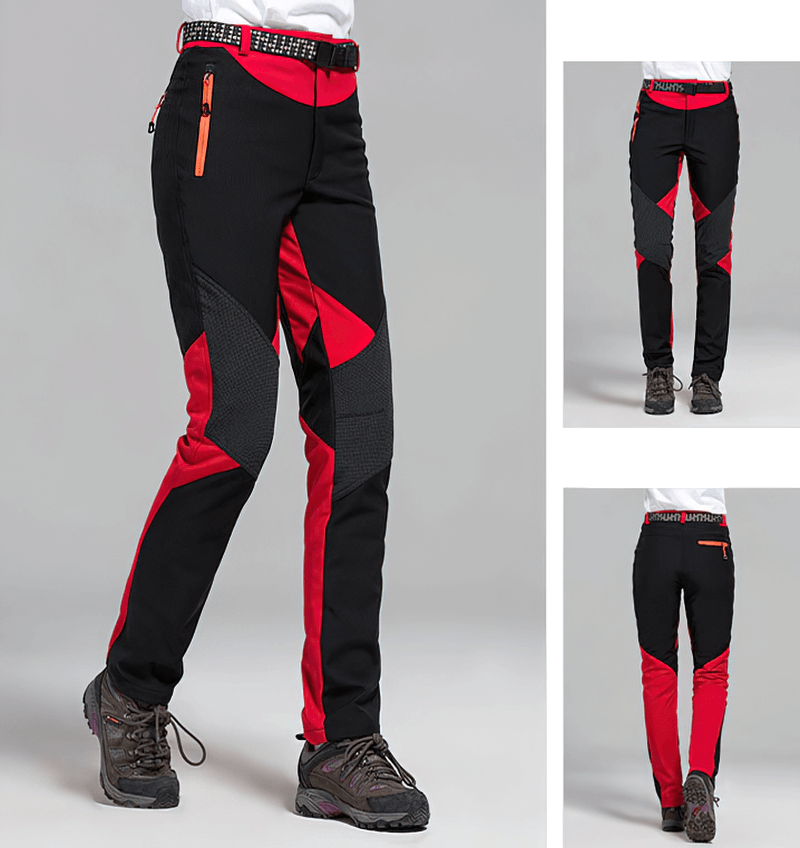 Women's red and black softshell skiing pants with fleece lining, showcasing windproof design and zipper closure.