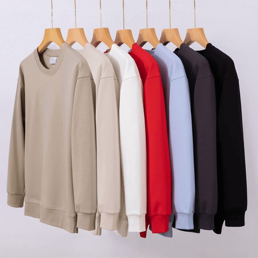 Assorted colors of women's solid O-neck sweatshirts hanging on wooden hangers, showcasing casual loose and comfy style.