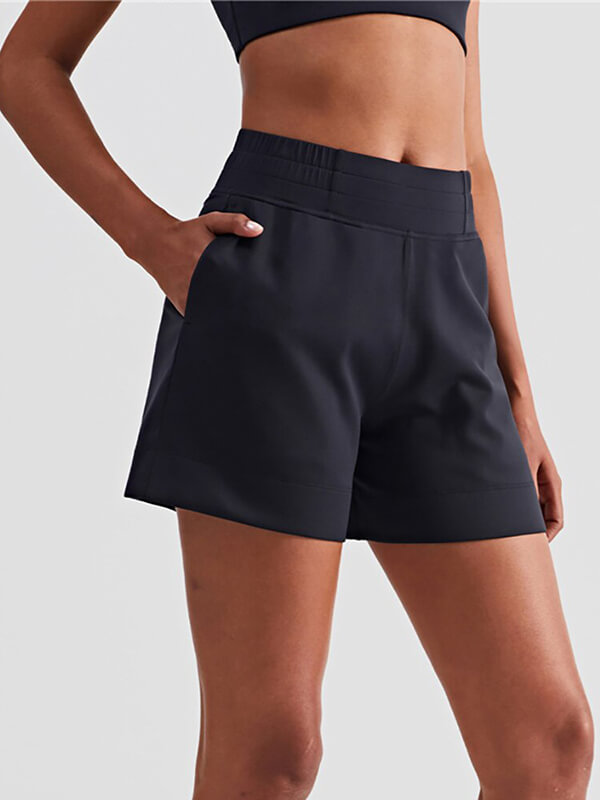 Women's black high-waist sports shorts with pockets, breathable acrylic fabric, perfect for active lifestyles.