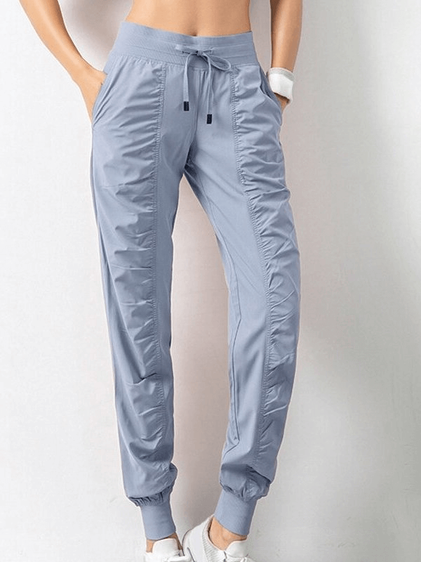 Women's Sports Joggers SF0177 with side pockets and cuffs, featuring a drawstring waist and pleated front, perfect for casual days.