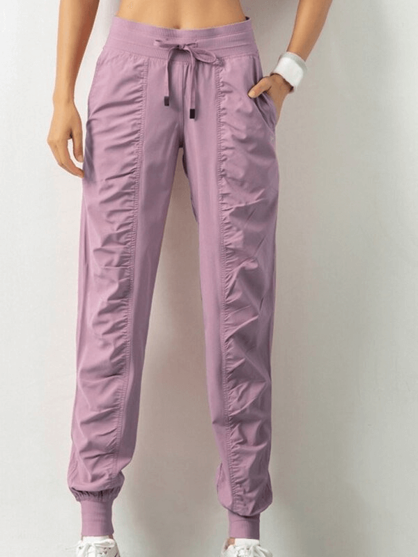 Women's sports joggers with side pockets, drawstring waist, and cuffed hems in solid lavender. Perfect for casual wear.