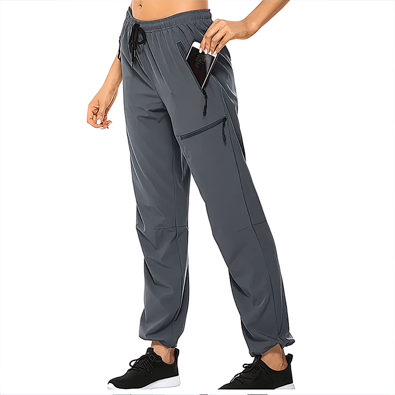 Woman wearing waterproof quick-drying hiking pants with pockets, elastic waist, and phone in pocket.