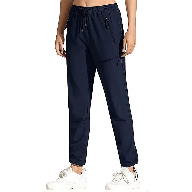 Women's waterproof quick-drying hiking pants with pockets, navy, elastic waist, perfect for outdoor adventures. Model wears white shoes.