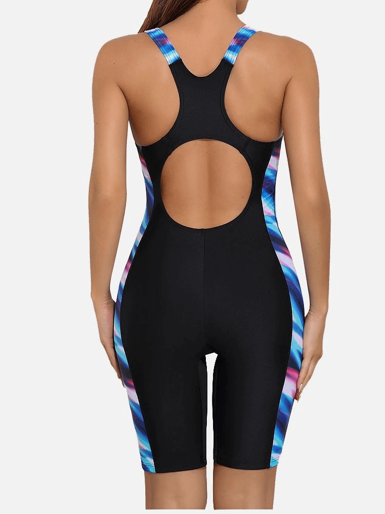 Women's sporty beach knee-length swimwear, black with colorful patchwork, racerback style, showcasing back design. Ideal for swimming or lounging.