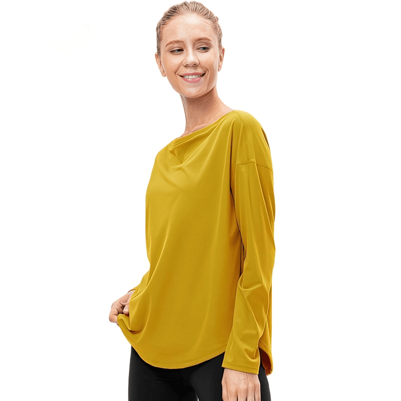Woman in mustard yellow sporty top with loose neckline and long sleeves, perfect for active lifestyle.