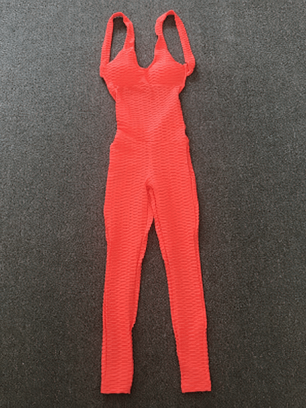 Vibrant red textured open-back yoga jumpsuit laid flat, showcasing breathable fabric and sleek design for comfort and style during practice.