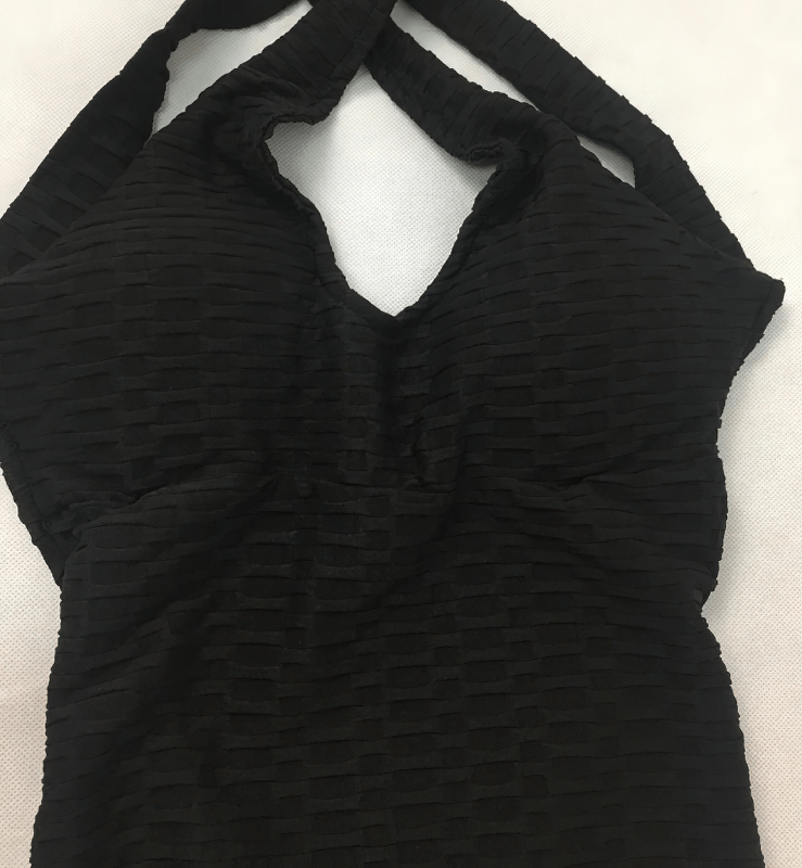 Women's black textured open-back yoga jumpsuit, anti-pilling, lightweight, breathable nylon fabric, ideal for practice and eco-friendly.