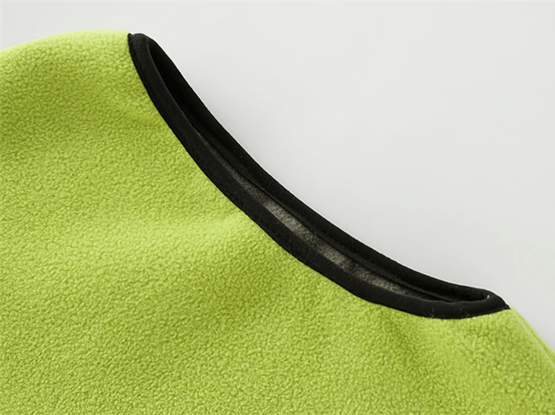 Close-up of a green women's thermal fleece vest with high collar, highlighting the soft texture and black trim.