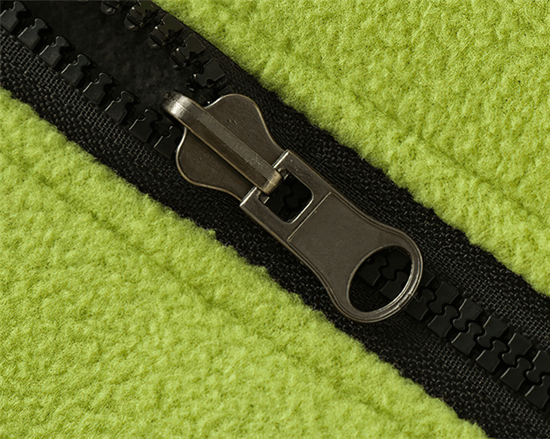 Close-up of a green thermal fleece fabric with a black zipper, showcasing texture and detail of a women's vest.