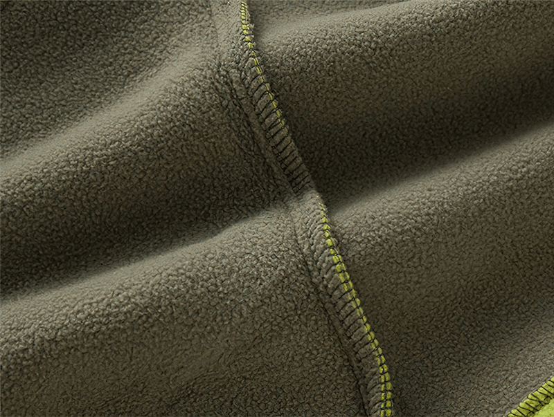 Close-up of high-quality green fleece fabric with detailed stitching, showcasing the texture and meticulous craftsmanship of the material.