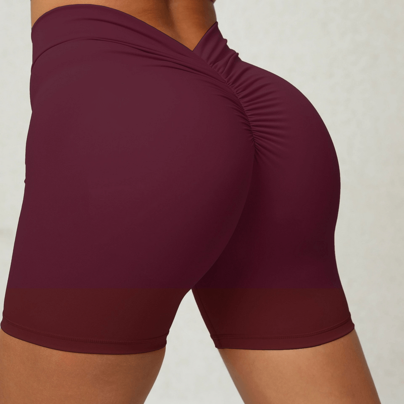 Women's solid color sports shorts in burgundy, featuring tight elastic fit for yoga and gym workouts, shown from the back.