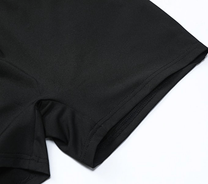 Close-up of black women's tight short jumpsuit with sleek polyester fabric and stylish cut, ideal for a fashionable look.