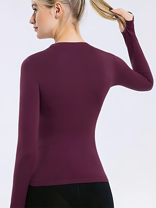 Women's maroon fitted long sleeve top with finger holes, perfect for yoga and workouts. Moisture-wicking, breathable fabric.
