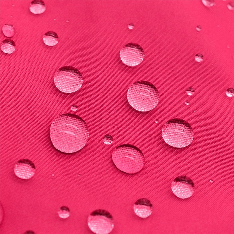 Close-up of water droplets on the waterproof fabric of a women's cycling jacket, showcasing durability and weather resistance.