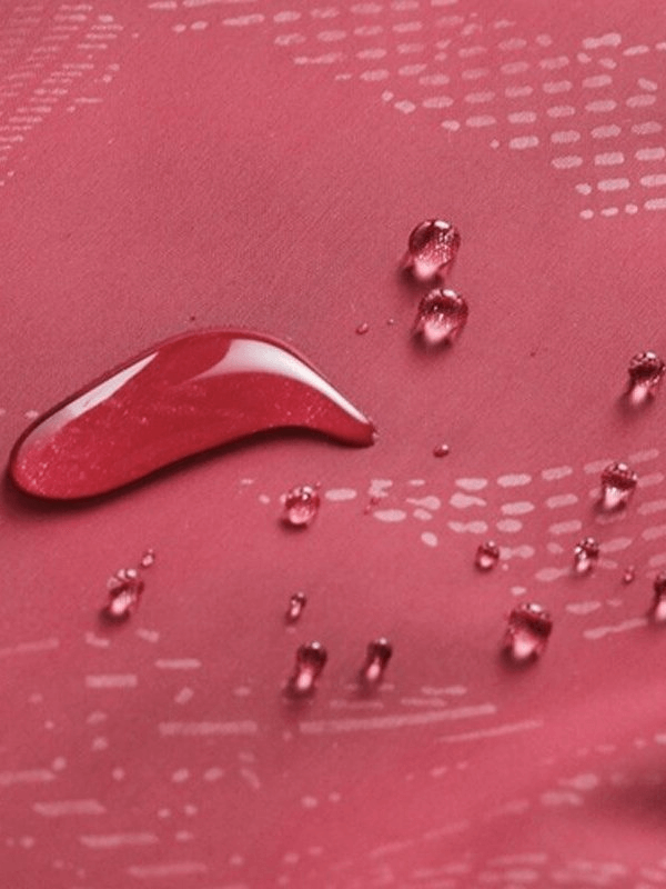 Close-up of water droplets on waterproof quick-drying women’s windbreaker fabric, highlighting water resistance and durability.