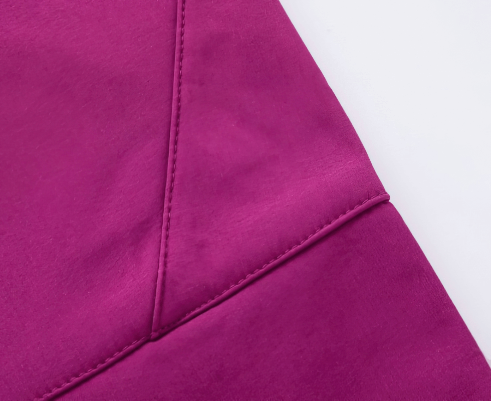 Close-up of vibrant magenta waterproof sports pants with detailed stitching, highlighting durable polyester fabric for hiking.