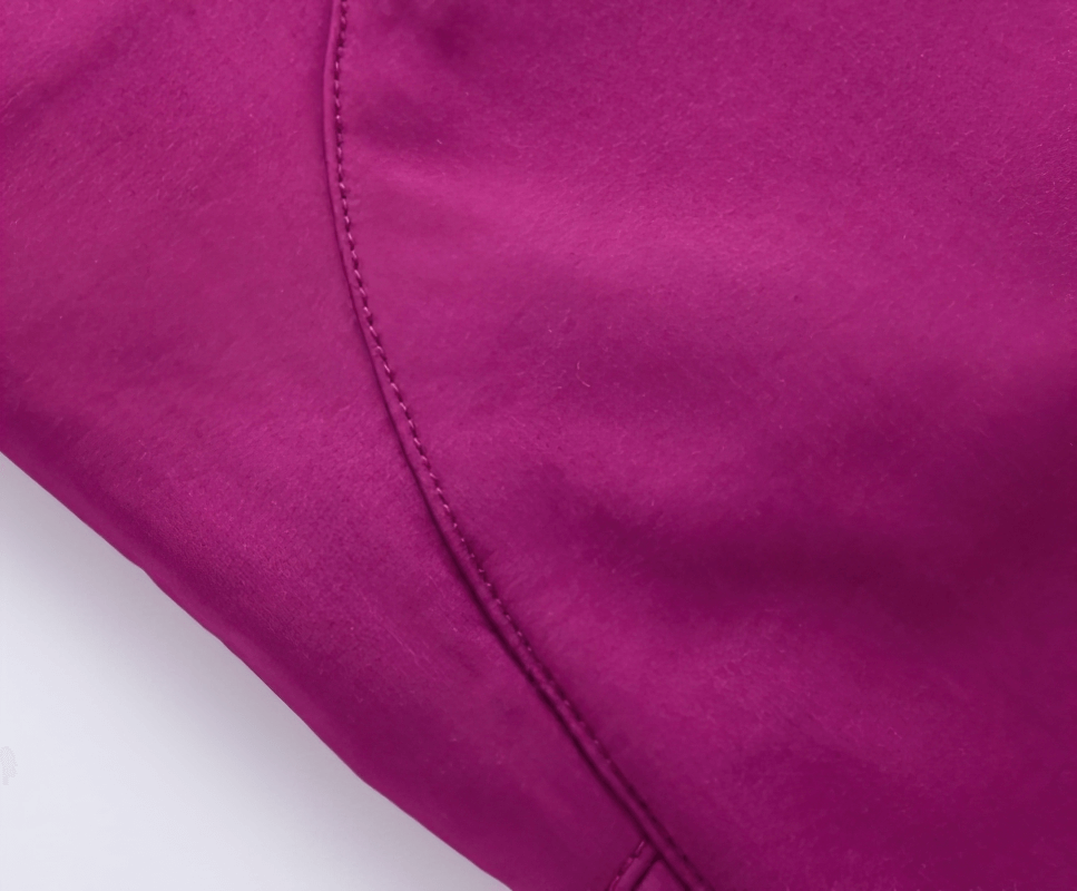 Close-up of women's waterproof sports pants in pink, showcasing durable stitching and soft polyester fabric for hiking and outdoor activities.