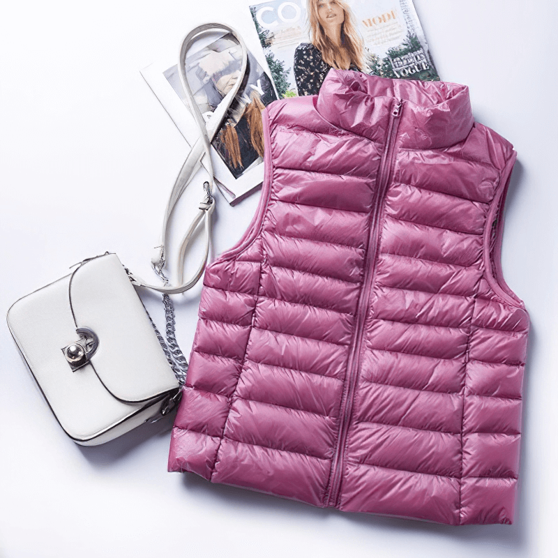 Pink women's windproof duck down vest with zipper and pockets, paired with a stylish handbag. Perfect for warmth and style.