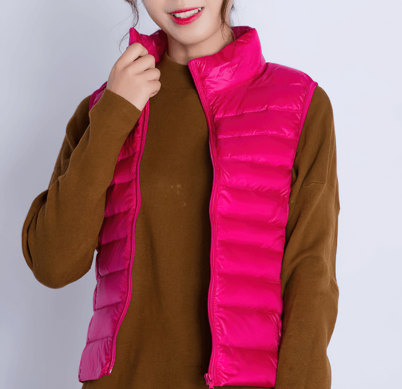 Woman wearing pink windproof duck down vest with pockets, featuring waterproof zipper and nylon material.
