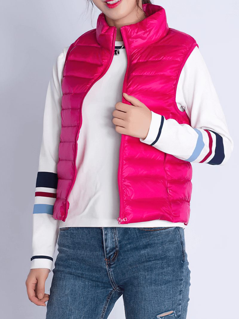 Woman in vibrant pink windproof duck down vest with pockets, showing slim and lightweight design, ideal for active lifestyle.