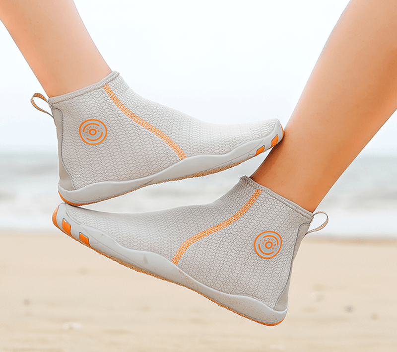 Two feet wearing zipper breathable water shoes for swimming, highlighted on a sunny beach background, showcasing comfort and style.
